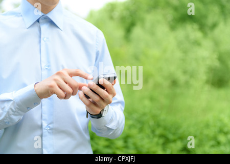 Young man using mobile smart phone in the park. Stock Photo