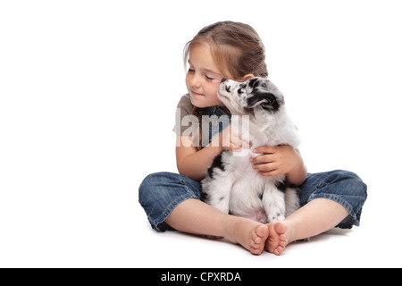little girl and a puppy in front of a white background Stock Photo