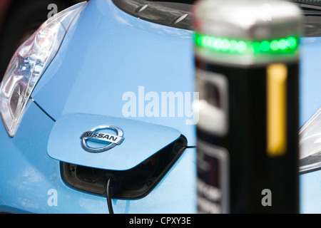 An electric Nissan Leaf vehicle at a recharging station on the street in Berkeley Square, London, UK. Stock Photo