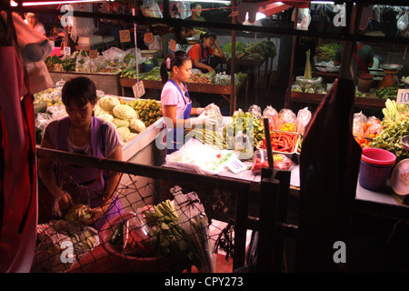 Thai merchants standing near vegetables stall , Mahachai market , Samut Sakhon province Stock Photo