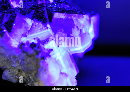 Flourite (calcium flouride) crystals fluorescing under ultraviolet light