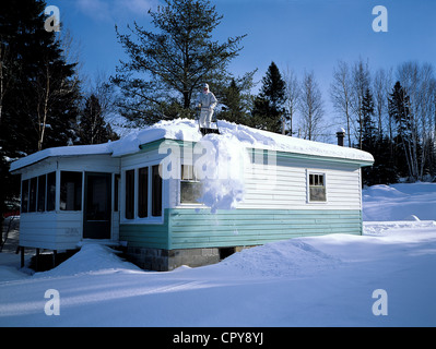 Canada, Quebec Province, removing snow for a house roof Stock Photo