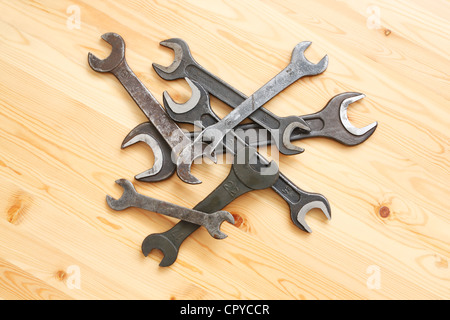 A lot of wrenches lying on a wooden surface Stock Photo
