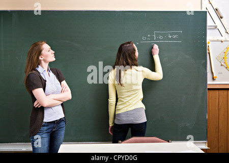 portrait of a young female teacher and a schoolgirl in the classroom ...