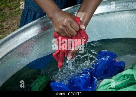 Black female hand washes clothing outside her rural home Stock Photo