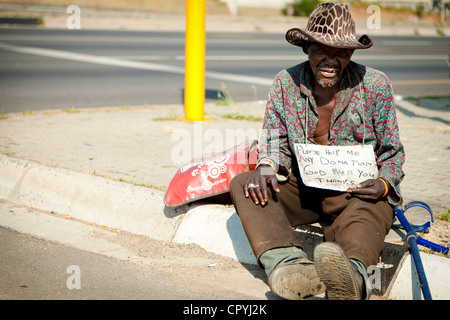 Shot of an African homeless man sitting on a roadside Stock Photo