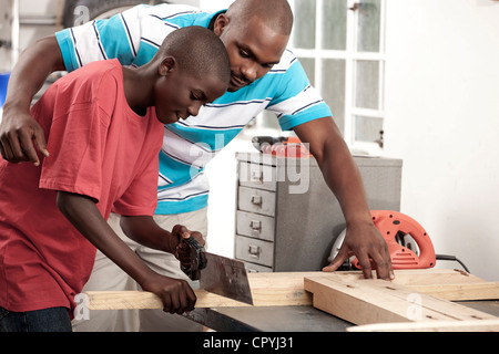 African Father and son working together in a workshop Stock Photo