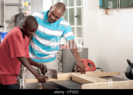 African Father and son working together in a workshop Stock Photo