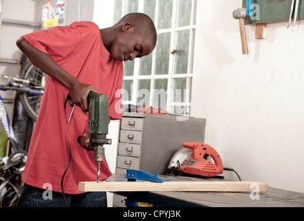 African child using drill in a workshop Stock Photo