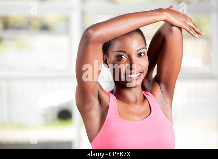 Young black female stretches in a gym Stock Photo
