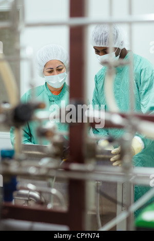 Laboratory technicians at work in medical plant with machinery and computers Stock Photo