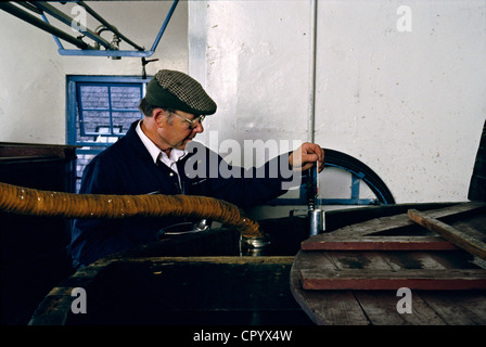 Scottish whiskey distillery worker checks mash tun Stock Photo