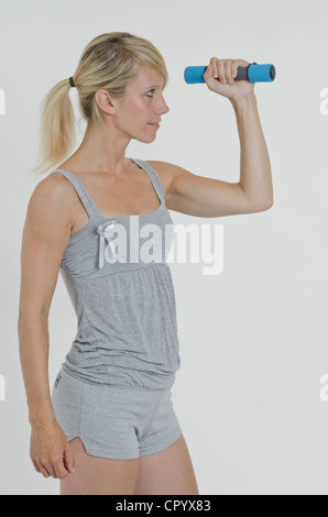 Young woman holding a small dumbbell in her left hand Stock Photo