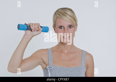 Young woman holding a small dumbbell in her right hand Stock Photo