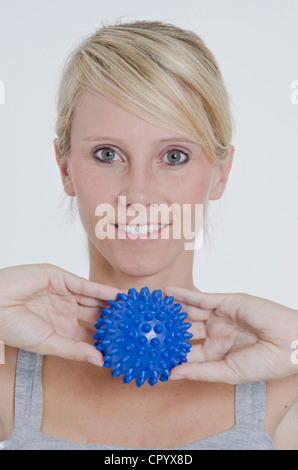 Woman with a blue spiky massage ball under her foot Stock Photo - Alamy