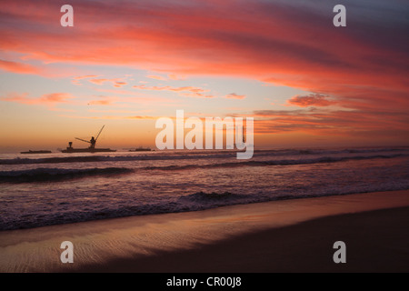 Sunset over submarine at sandy beach Stock Photo