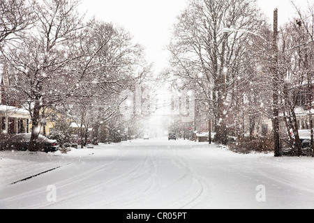 Snow falling on suburban street Stock Photo