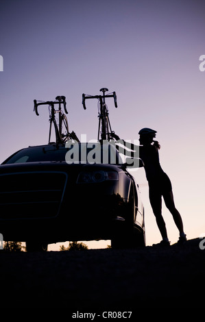 Mountain biker attaching bikes to car Stock Photo