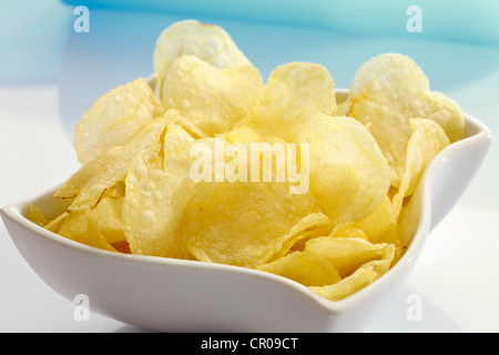 Salted potato chips in a porcelain bowl Stock Photo