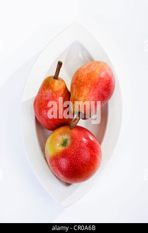 Red apple and two red pears on a plate Stock Photo