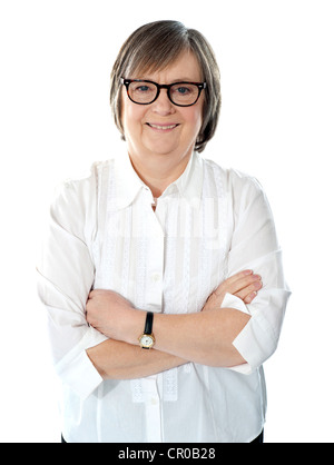 Senior female business executive in white shirt posing with crossed arms Stock Photo