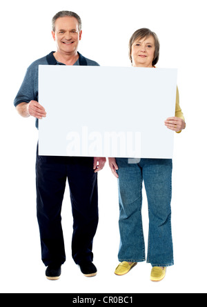 Happy senior couple holding a white placard. Full length portrait Stock Photo