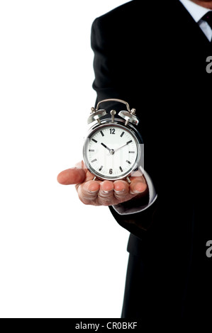 Cropped image of a man with alarm clock on his palm. Showing it to camera Stock Photo