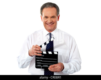 Aged corporate male holding clapperboard. Shot on white background Stock Photo