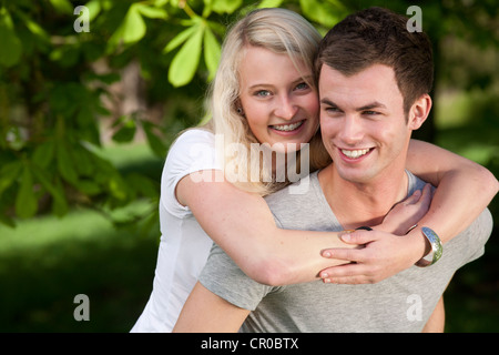 Young woman embracing a young man in a park in spring Stock Photo