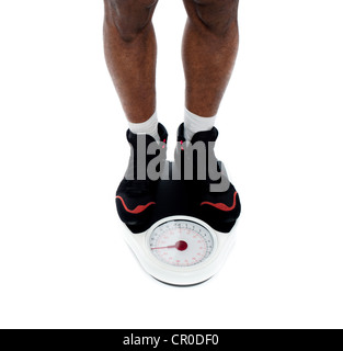 Man's feet on weighing scale isolated over white. Closeup Stock Photo