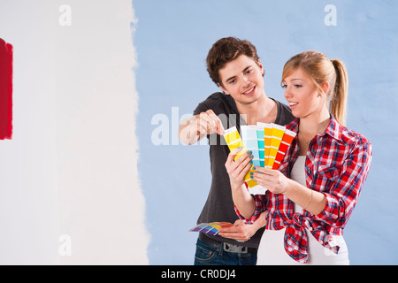 Young couple using colour cards to select a wall paint colour Stock Photo