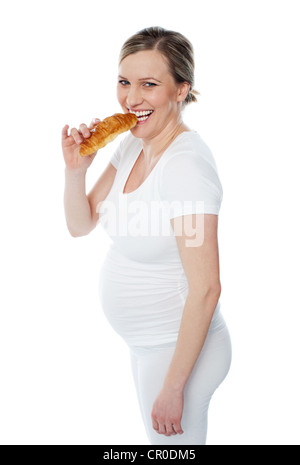 Pretty pregnant lady eating fast food and smiling at camera Stock Photo