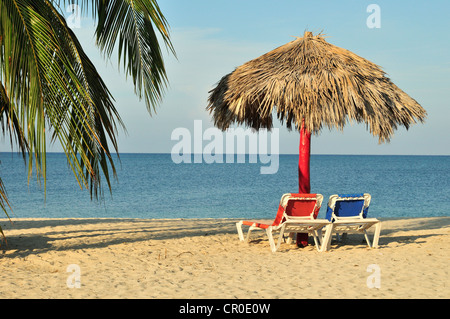 Empty sunbeds under a parasol on the beach of Playa Ancón near Trinidad, Cuba, Caribbean Stock Photo