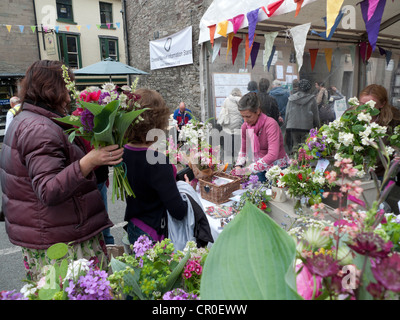 People buying cut flowers from locally grown flower shop street market stall during the Hay book Festival in Hay-on-Wye Wales UK KATHY DEWITT Stock Photo