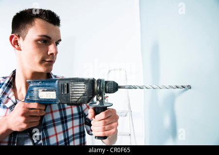 Young man using a drill Stock Photo