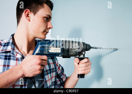 Young man using a drill Stock Photo