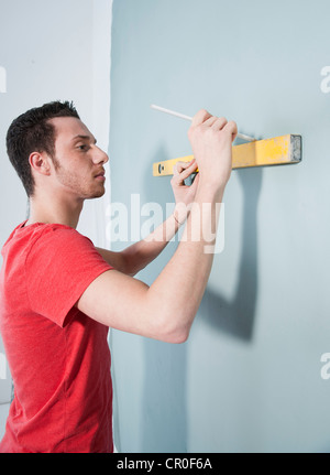 Young man using a spirit level Stock Photo