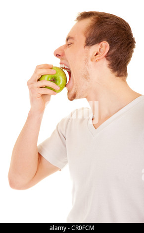 Young handsome man is biting a green apple on his palm. On white background. Stock Photo