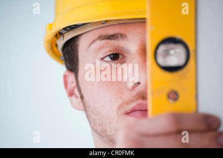 Young tradesman using a spirit level Stock Photo