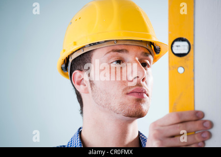 Young tradesman using a spirit level Stock Photo