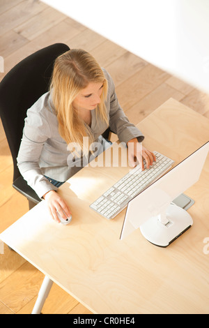 Young woman working on a computer in her office Stock Photo - Alamy
