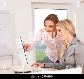 Two women working together on a computer Stock Photo