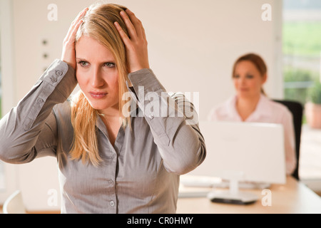 Colleagues in office, stressed woman Stock Photo