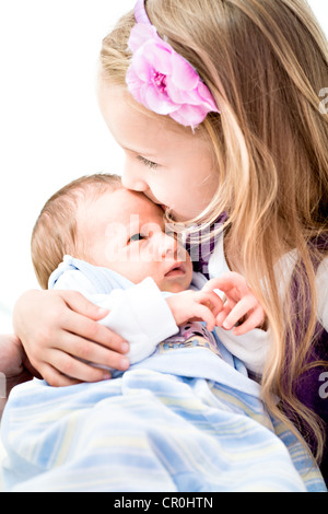 Baby boy, 1 month, being held by his sister Stock Photo