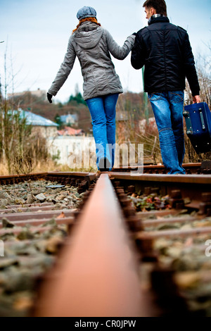 Young couple walking on railway tracks Stock Photo