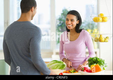 USA, New Jersey, Jersey City, Couple chopping vegetables in kitchen Stock Photo