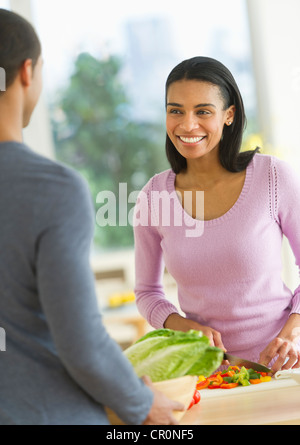 USA, New Jersey, Jersey City, Couple chopping vegetables in kitchen Stock Photo