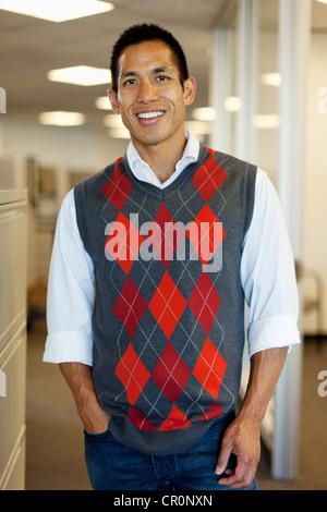 Smiling mixed race businessman standing in office Stock Photo
