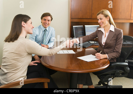USA, New York, New York City, Businesswoman and clients shaking hands in office Stock Photo