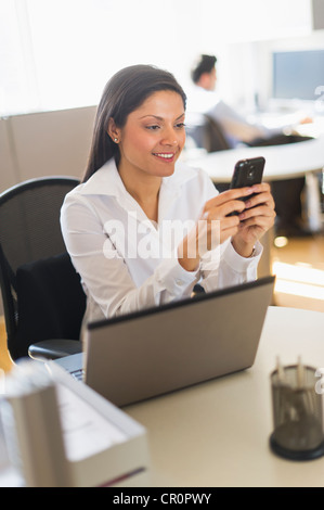 Indian businessman text messaging and smiling Stock Photo - Alamy